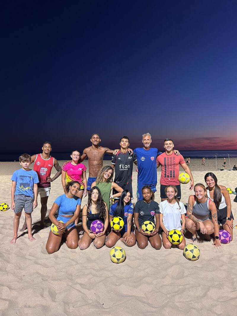 Training group at dusk holding footvolley balls