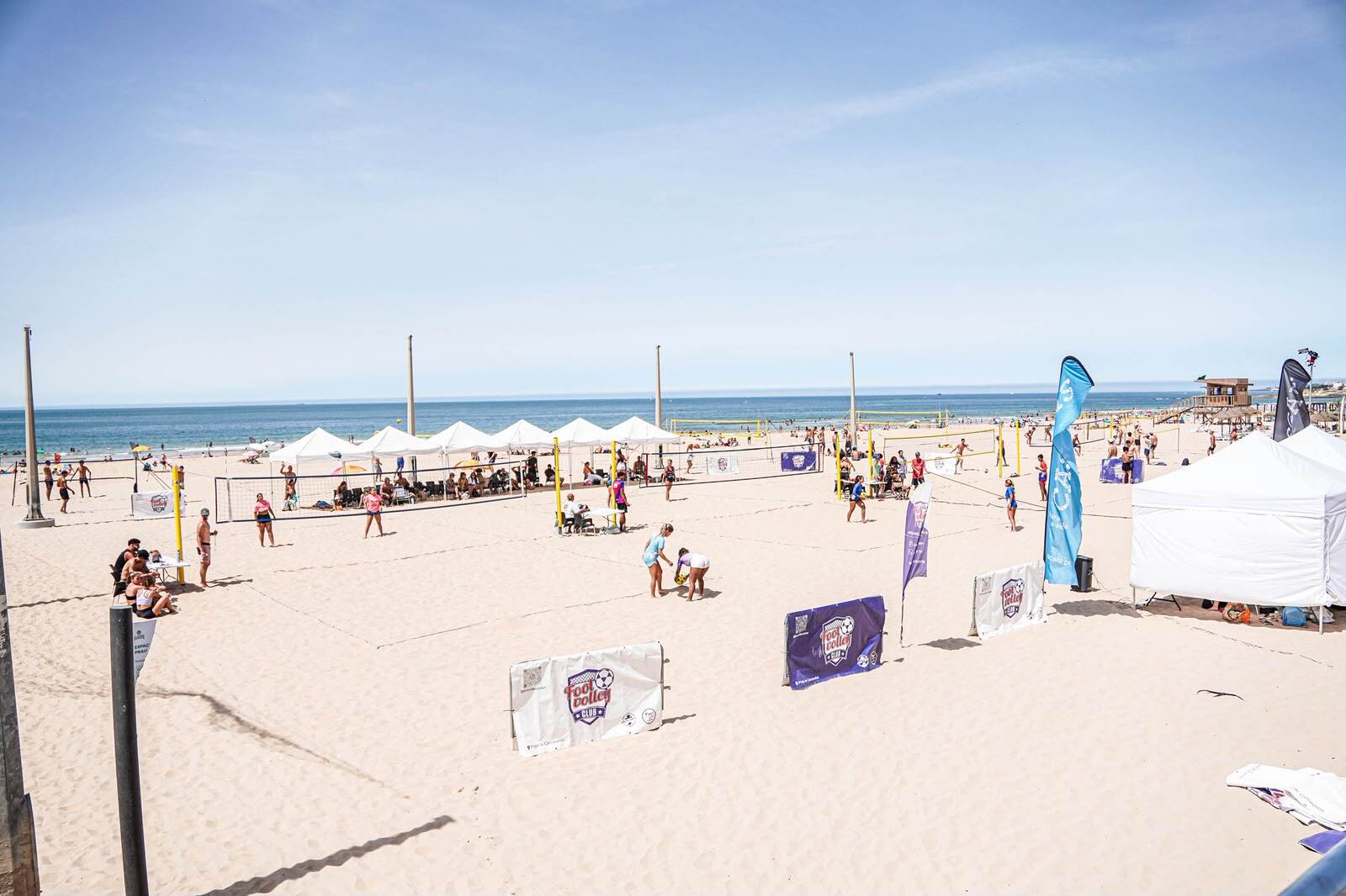 Footvolley Club tournament courts on the beach with banners and tents